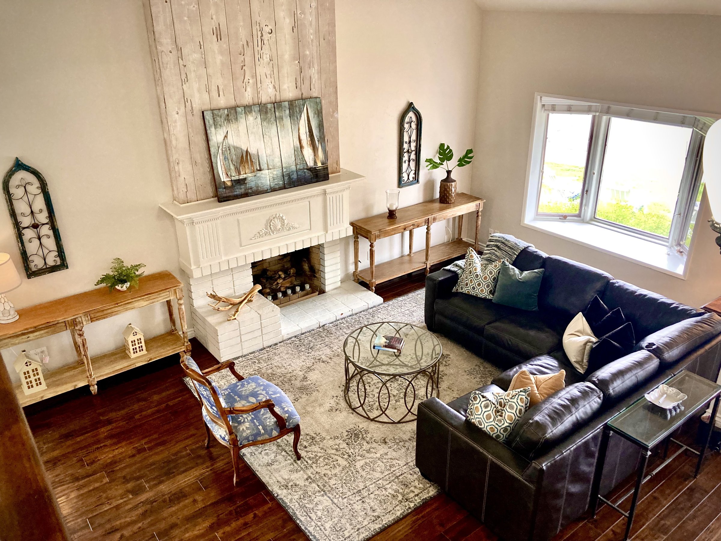 Tamara Shoemaker Interior Design hero photo — a warm living room with a white fireplace mantel and a leather sectional